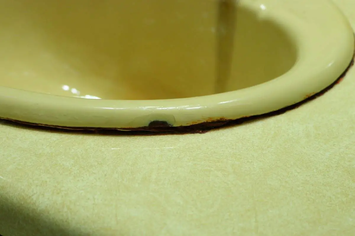 Chipped yellow sink edge before bathroom remodel