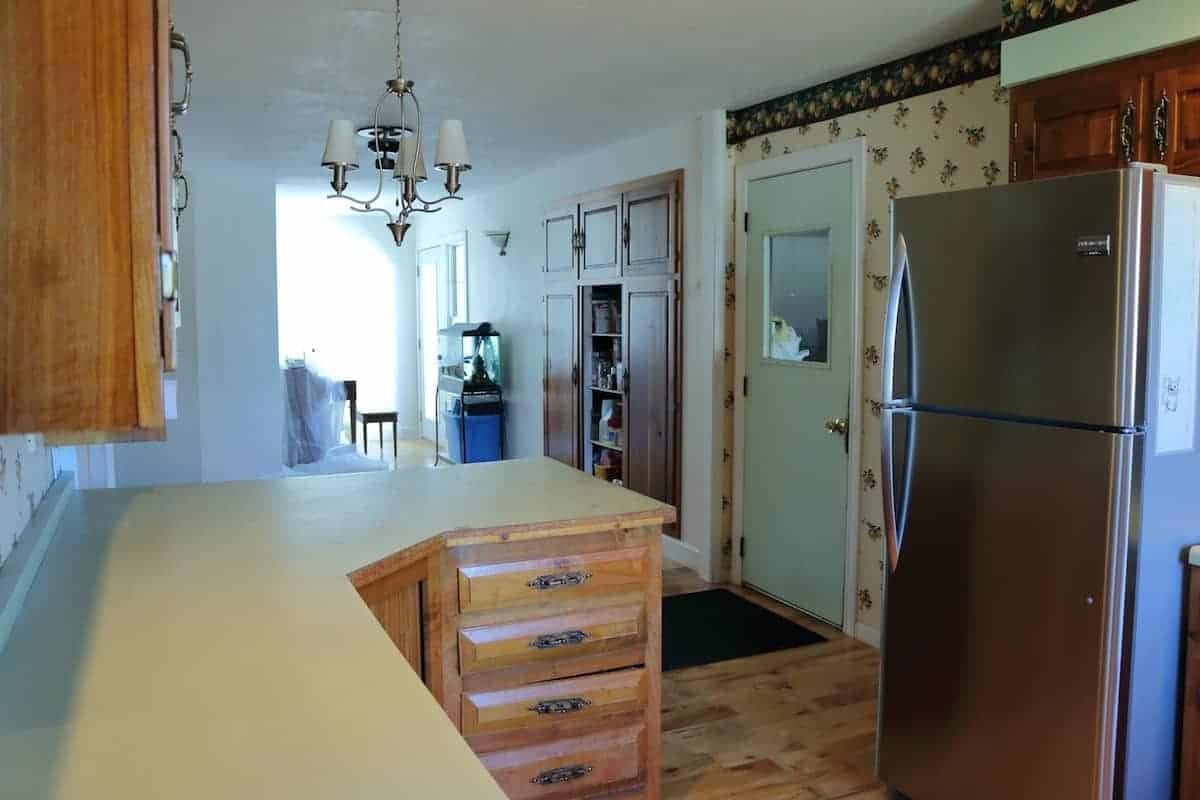 Kitchen remodel - before picture of green counters, hickory cabinets and stainless steel refrigerator