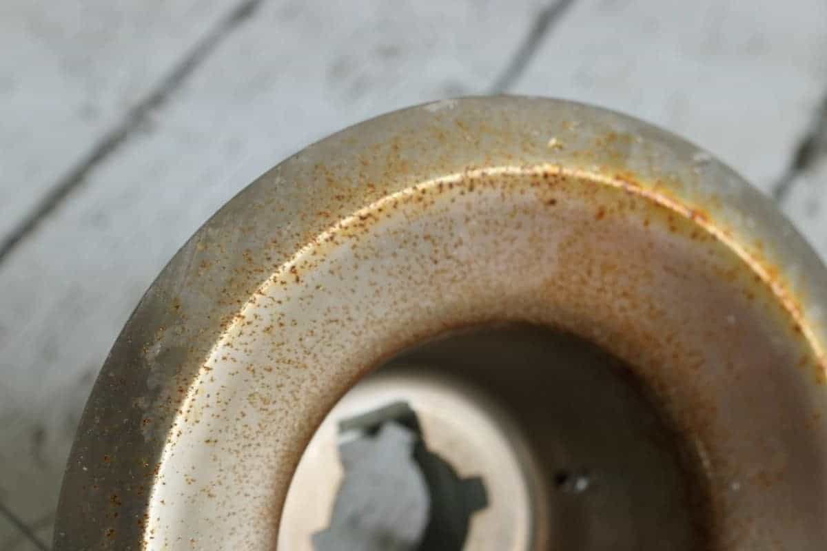 Close-up of recessed can light metal trim ring with rust
