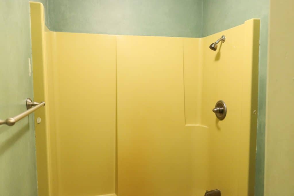 bathtub refinishing kit before picture of a yellow shower