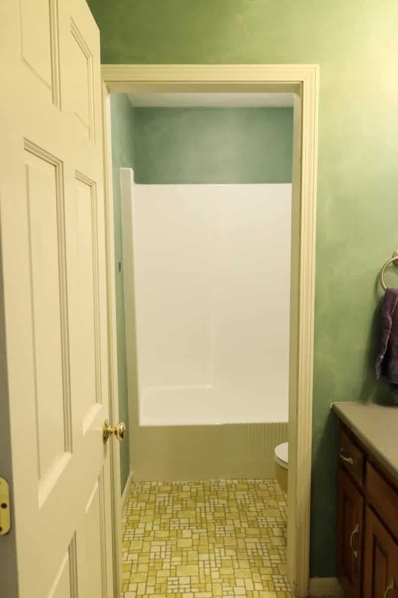 Photo of bathroom with white refinished tub, green walls and yellow floor