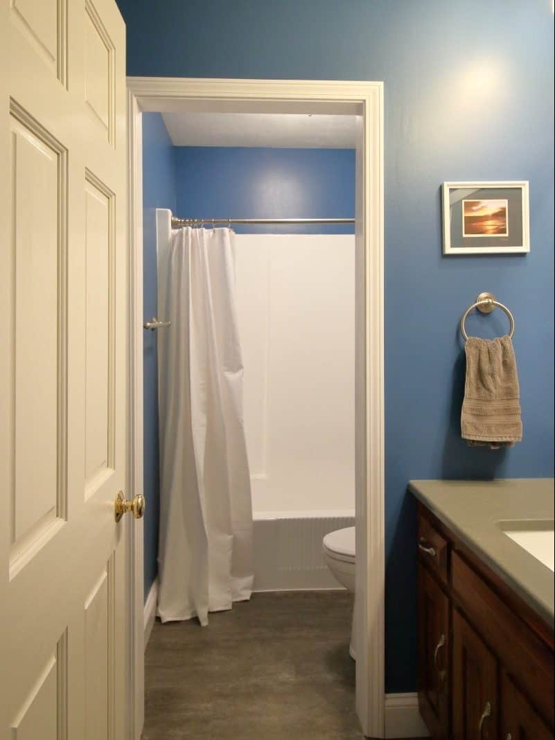1970s bathroom remodel - updated with dark blue walls, grey vanity, white plumbing fixtures