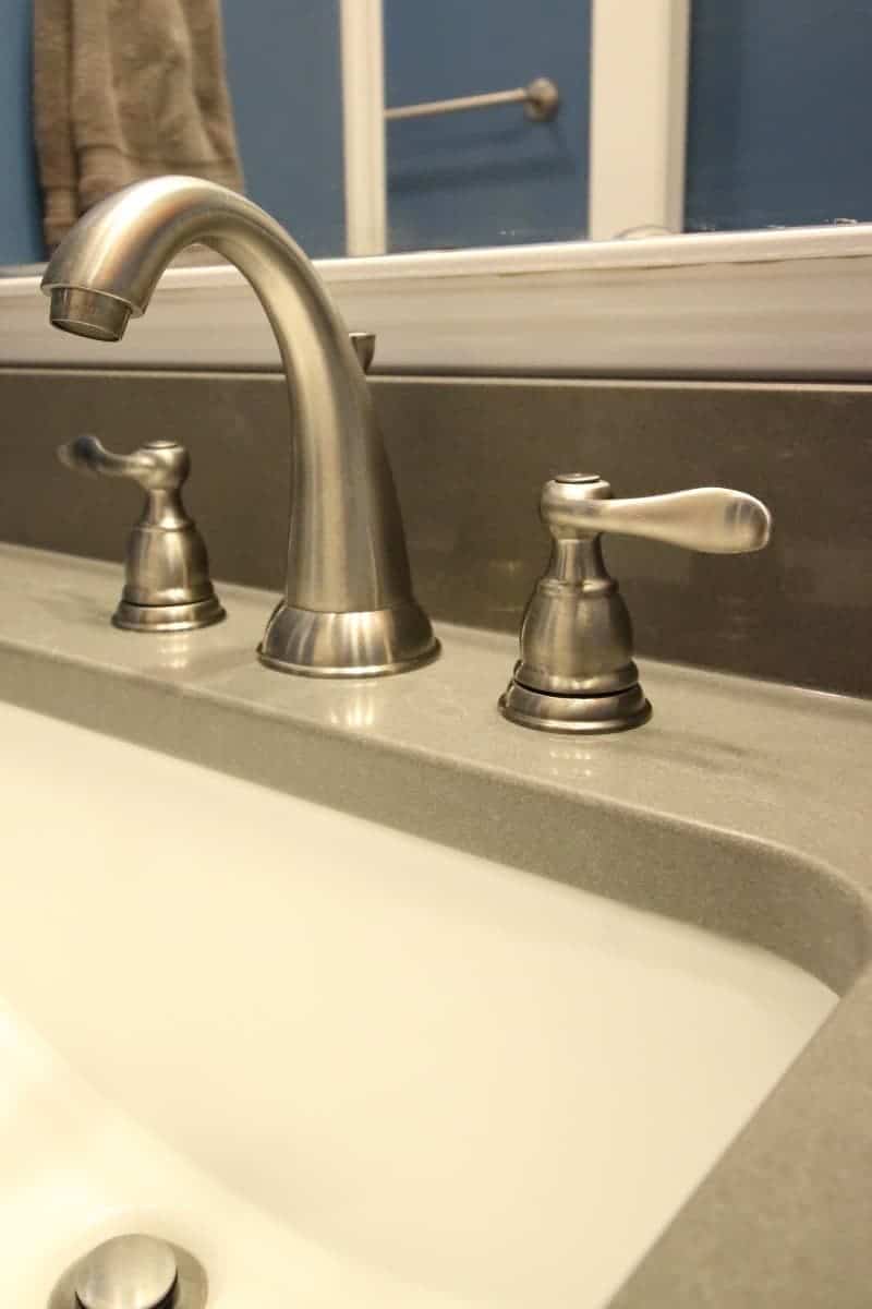 Bathroom makeover with satin nickel faucet and dark grey quartz countertop