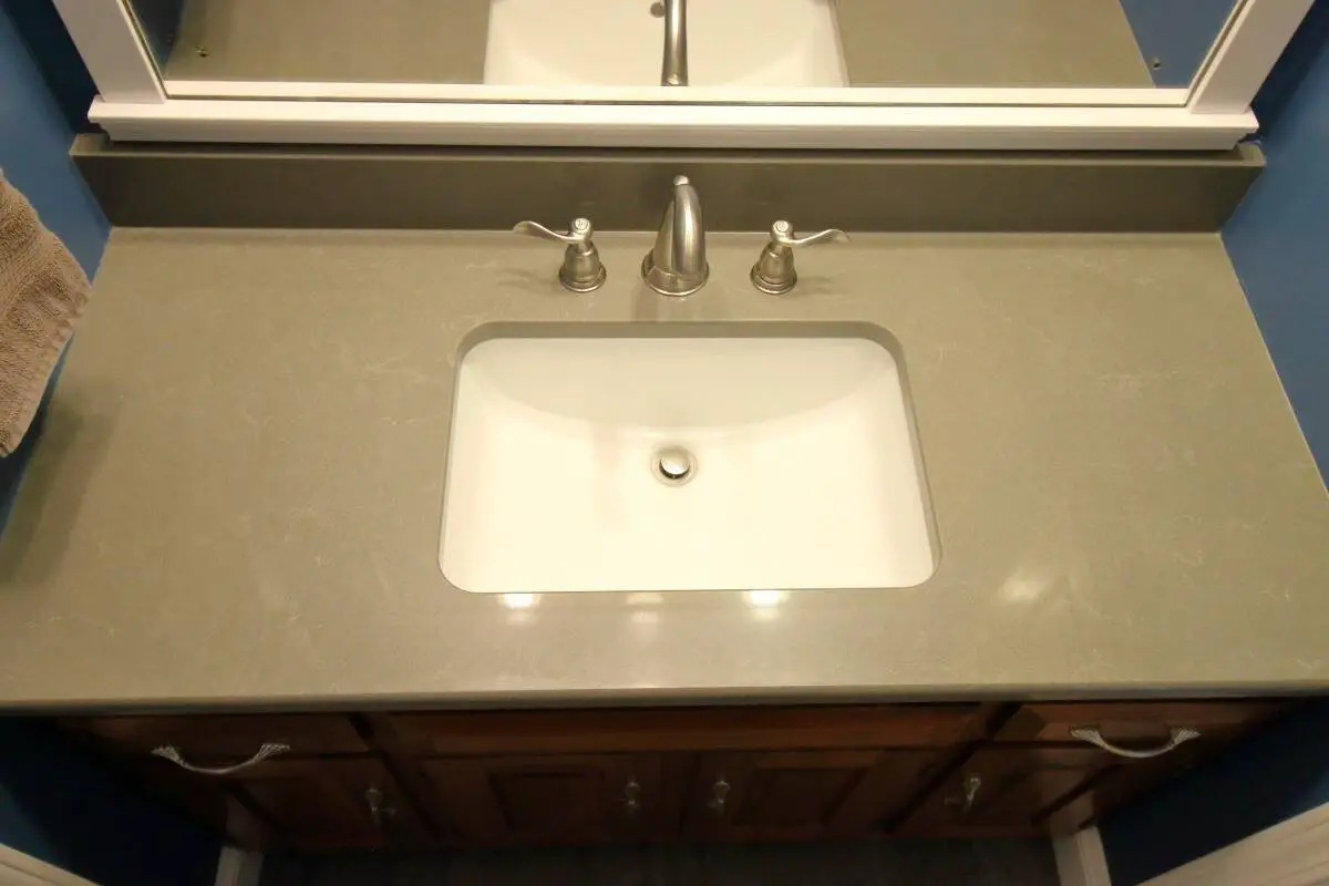 Dark grey quartz countertop, white rectangular sink, satin nickel faucets