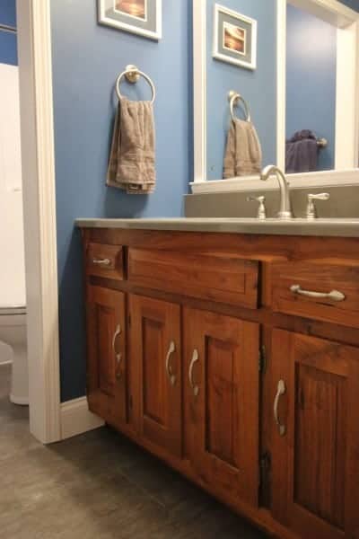 Bathroom remodel - hickory cabinet, dark grey floor & quartz countertop, and dark blue walls