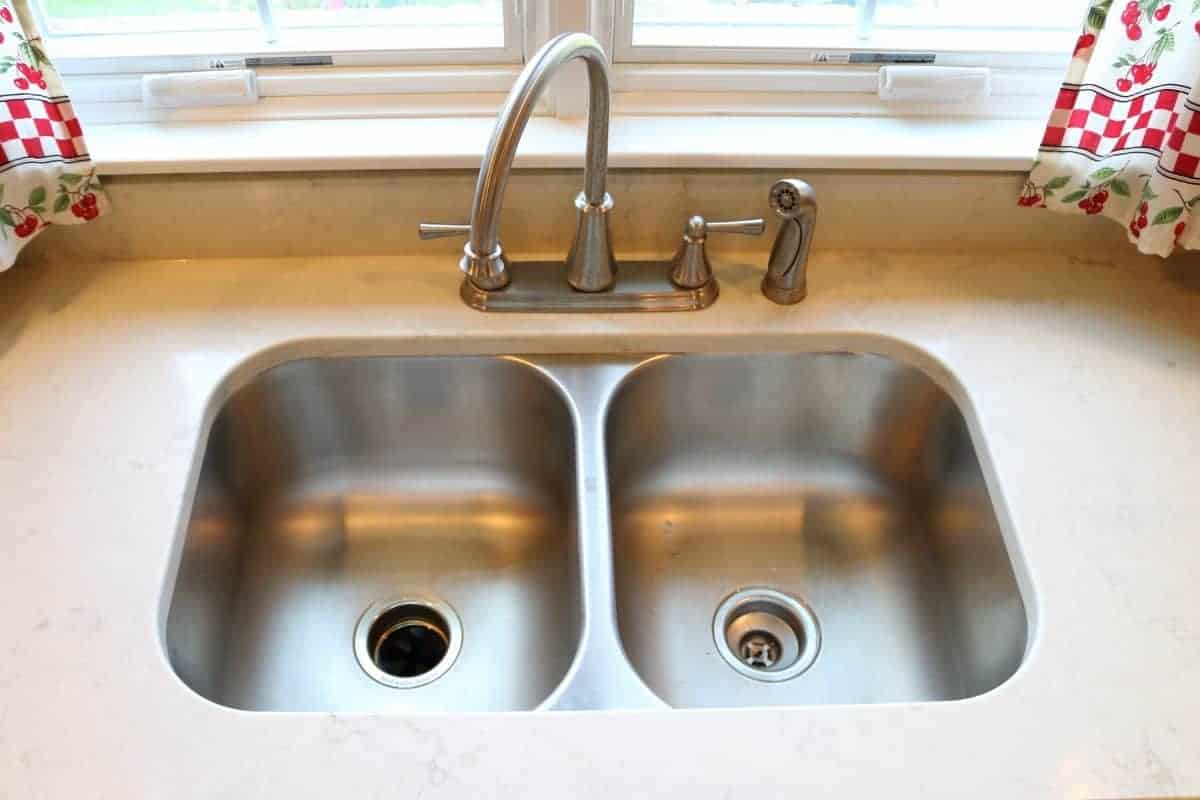 Kitchen remodel with stainless steel double bowl undermount sink with white quartz countertop.