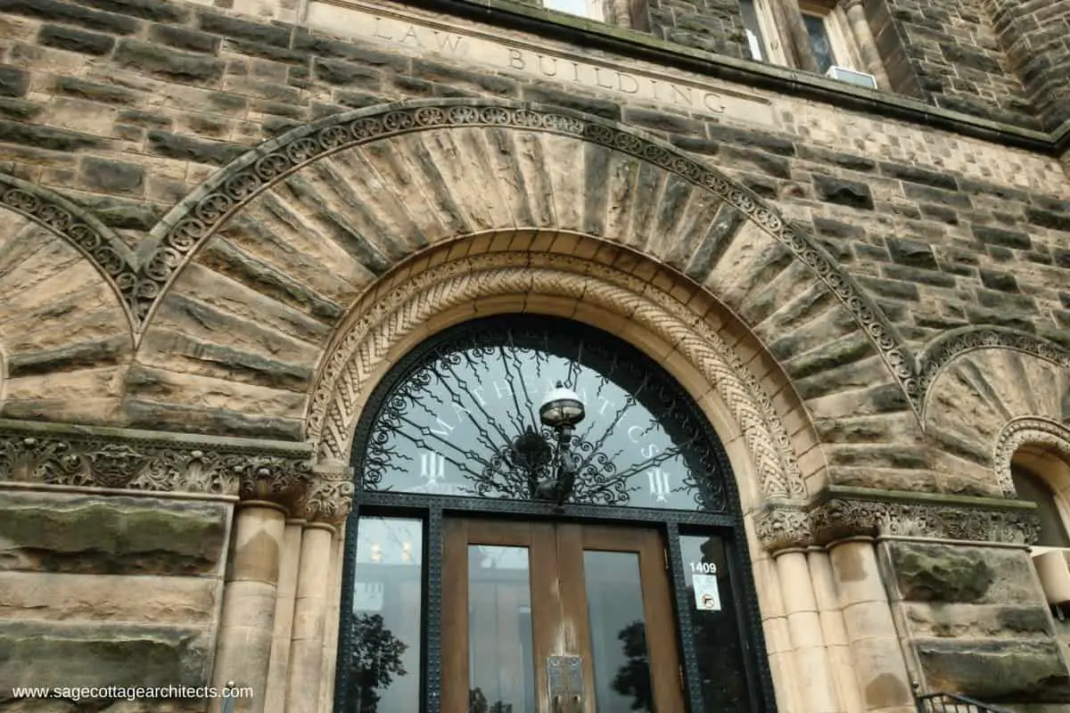 Rough cut stone arched entry to Richardsonian Romanesque university building.