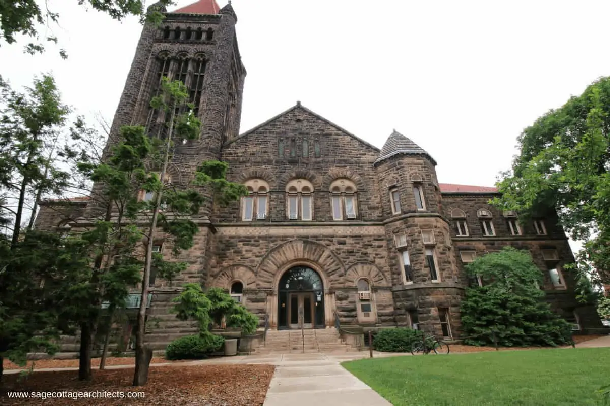 Large Richardsonian Romanesque university building made of stone with bell tower.