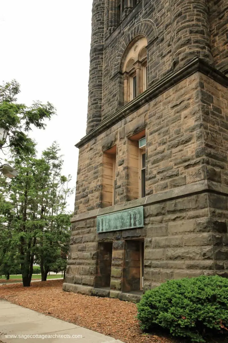 Base of massive Richardsonian Romanesque university building with ashlar limestone walls