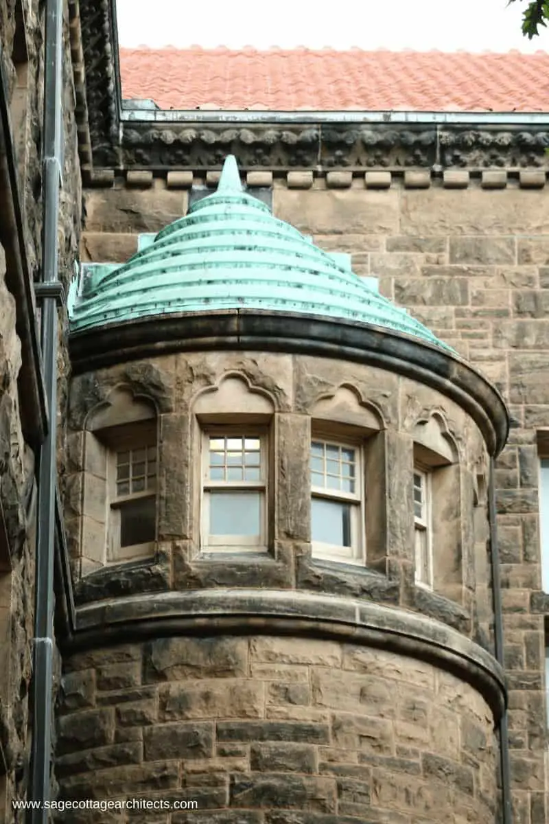 Ashlar limestone building with conical turret and copper clad roof.