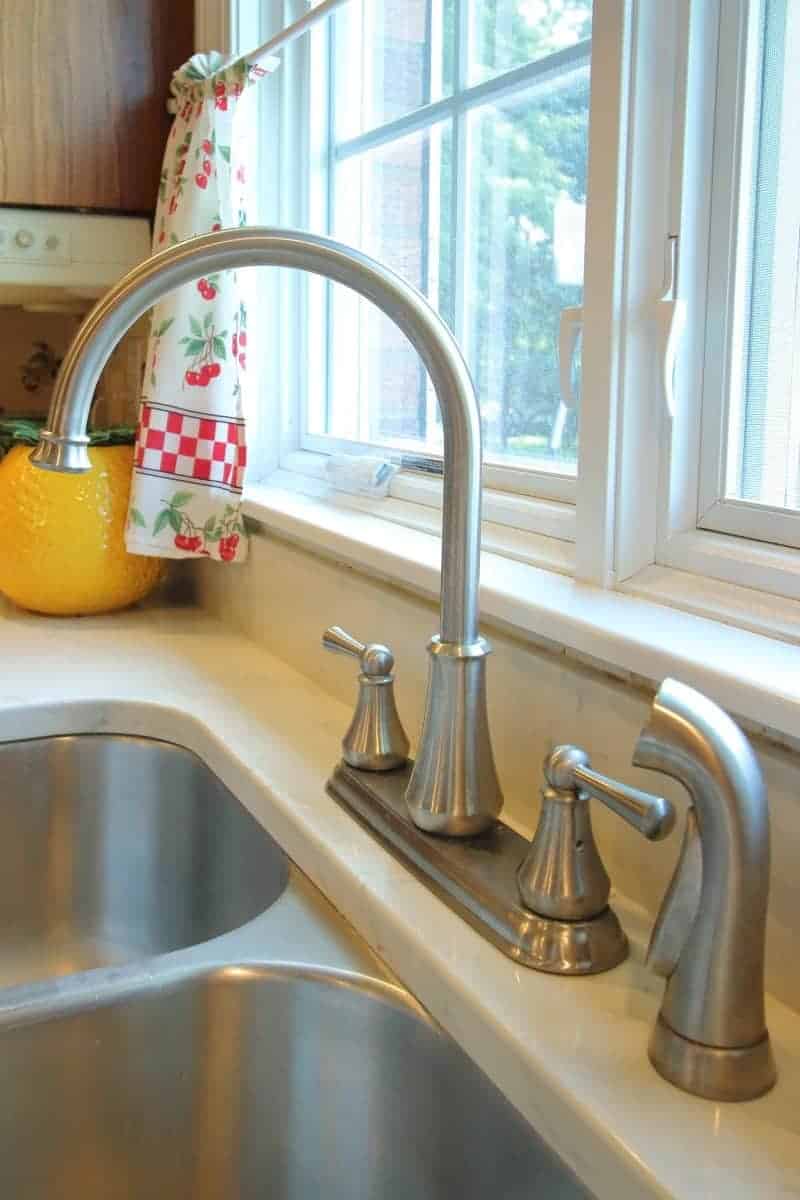 Kitchen remodel with white quartz countertop, undermount stainless steel sink and brushed nickel faucet.