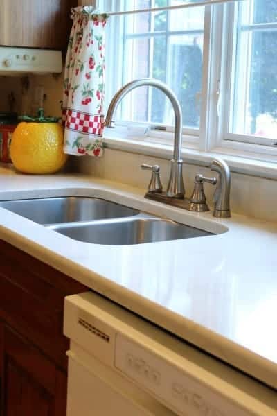 Kitchen remodel with white quartz countertop, undermount stainless steel sink and brushed nickel faucet.