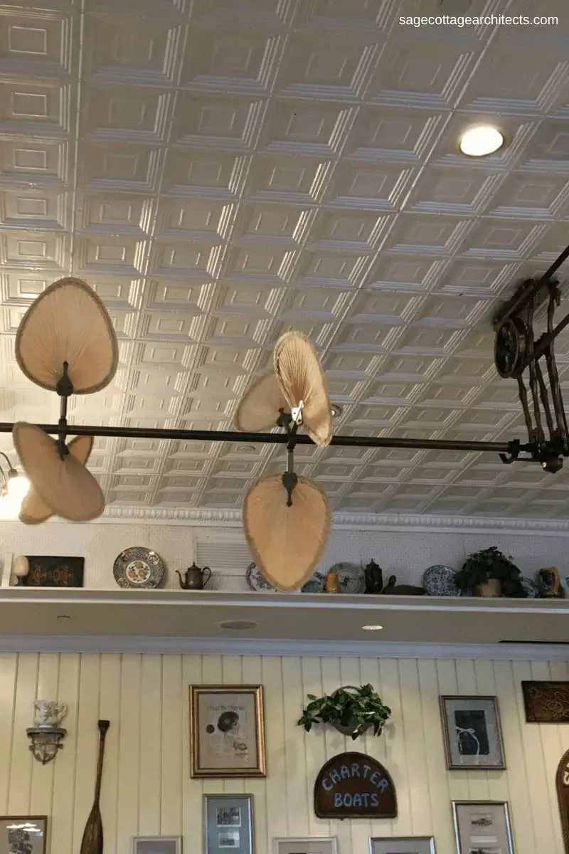 White tin ceiling, ceiling fan, and art work in Olivia's Cafe at Disney's Old Key West Resort. 