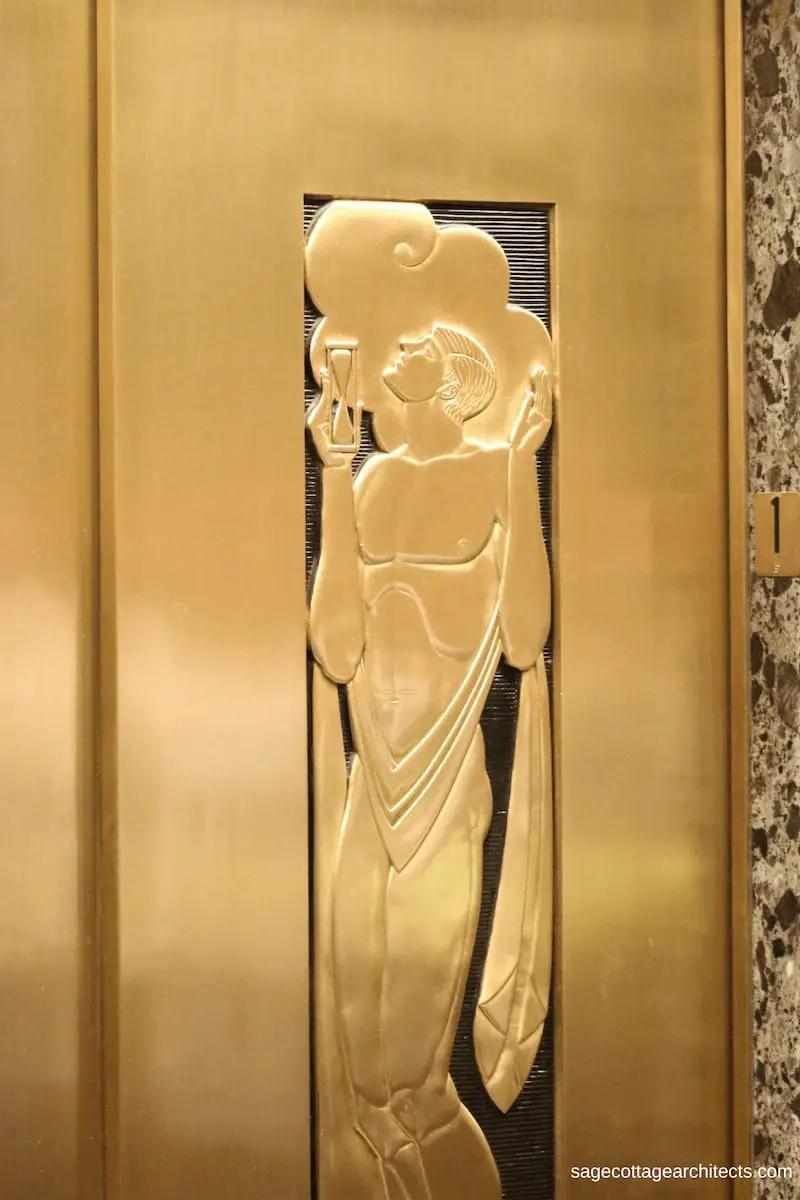 Art Deco gold elevator door with carving of a man holding a sand hour glass