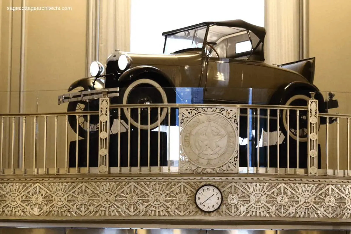 Model A car sitting on a balcony with Art Deco nickel relief panel and railing.
