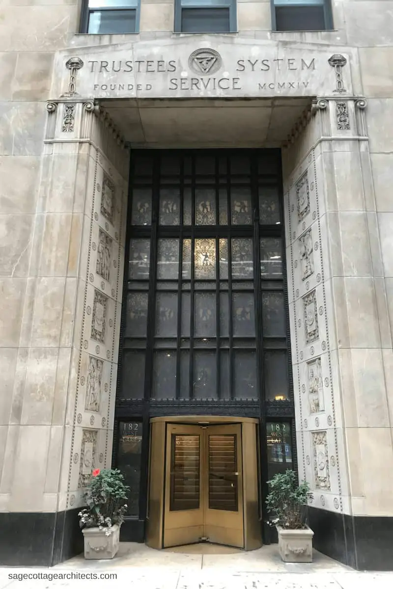 Art Deco Architecture: building entrance with black metal decorative panels and bronze revolving door.