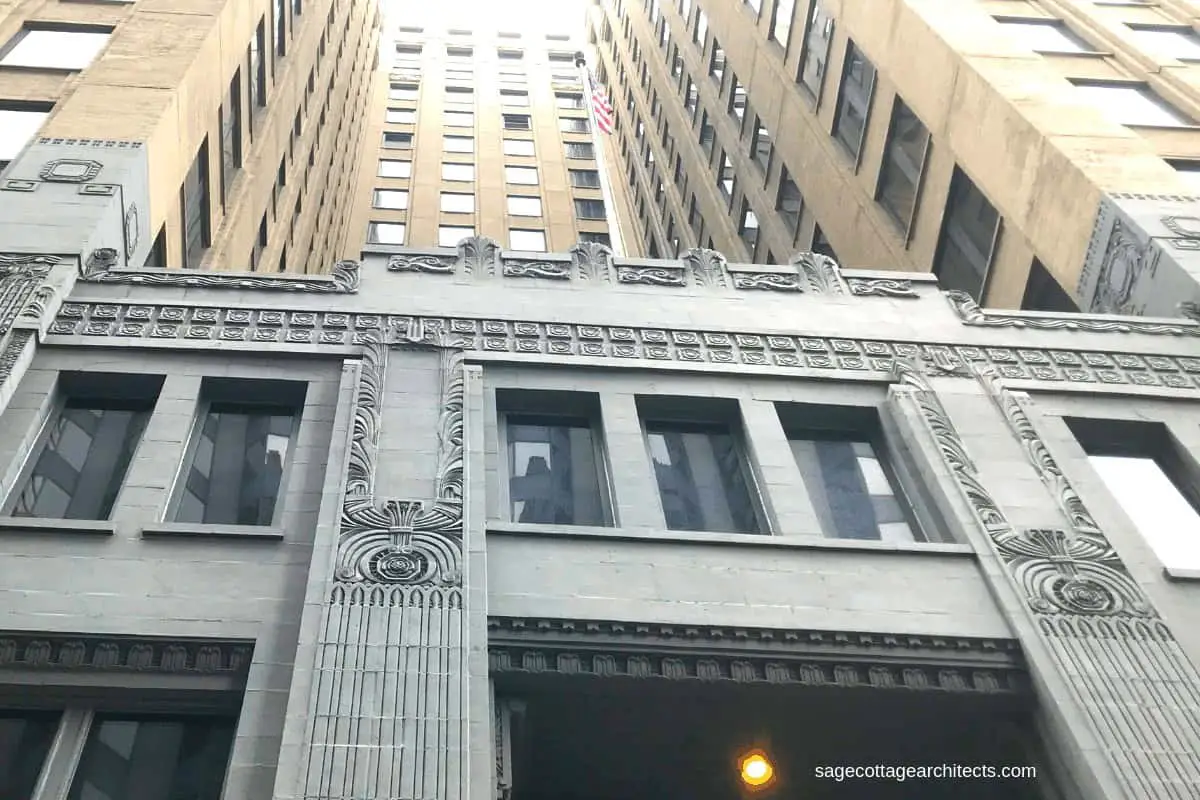 Looking up at an Art Deco skyscraper with grey base and tan upper floors