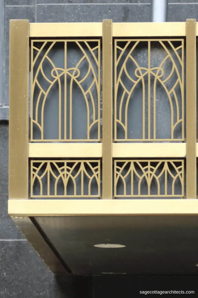 Gold Art Deco entrance canopy on dark grey-green wall 