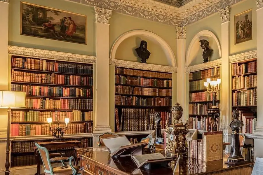 Ornate library with large built-in bookshelves.