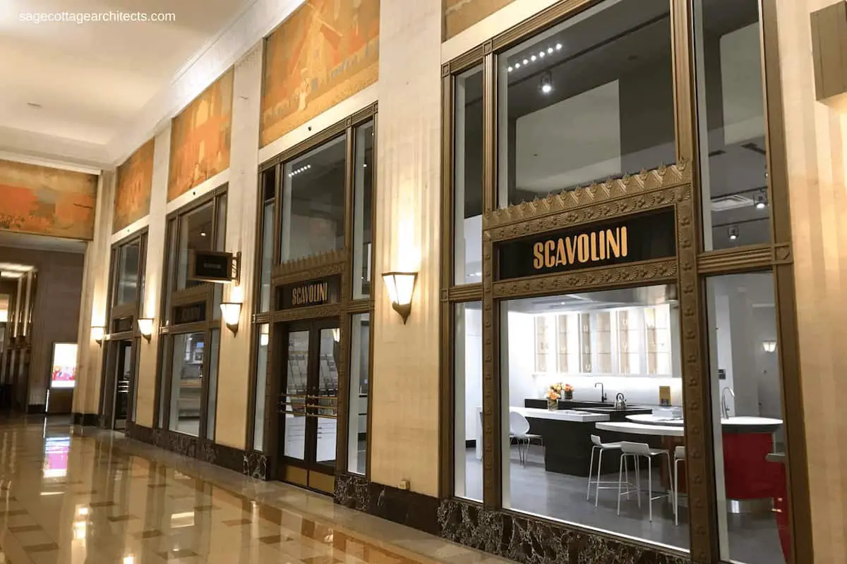 Art Deco lobby with terrazzo floors, decorative window frames and large murals. 