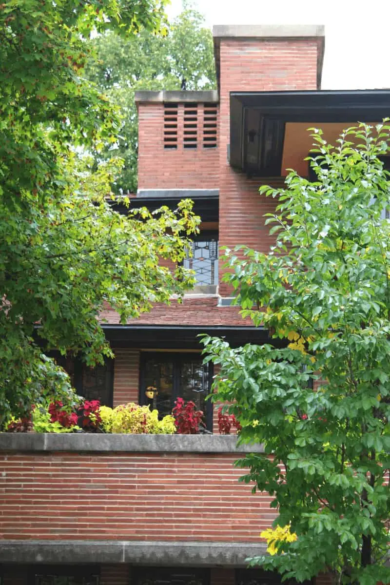 Prairie style home with red brick, cream stucco, and black eaves.