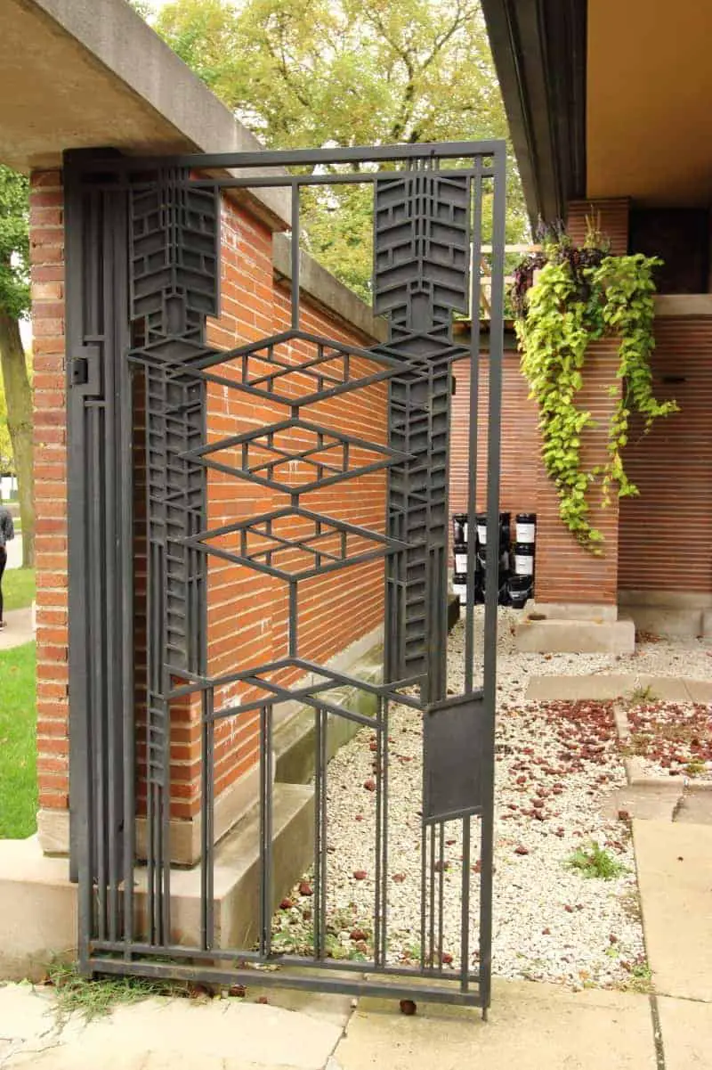 Wrought iron gate with Prairie style pattern in a brick wall. 