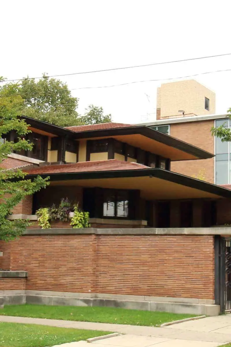 Low sloped red roofs and brick garden wall of the Robie House.