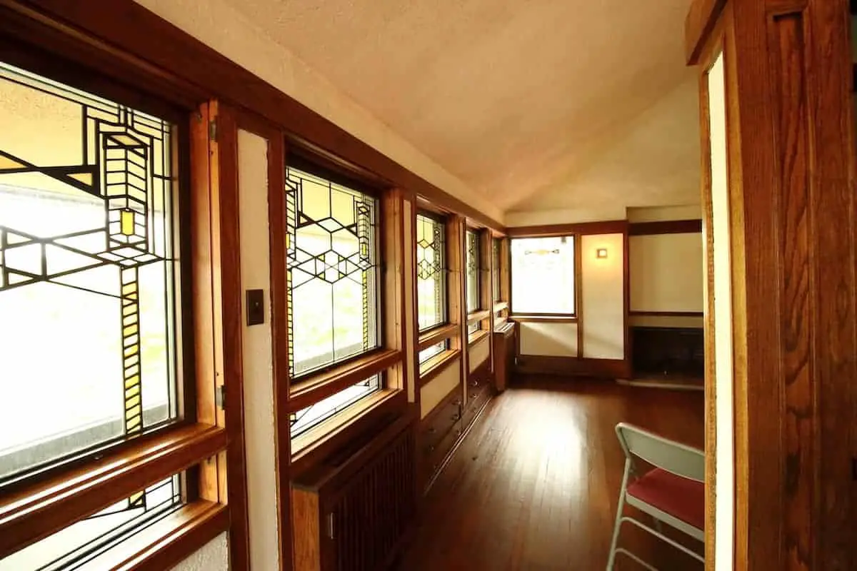 Prairie Style home interior with stained glass window wall, oak floors and cream colored walls and ceiling.