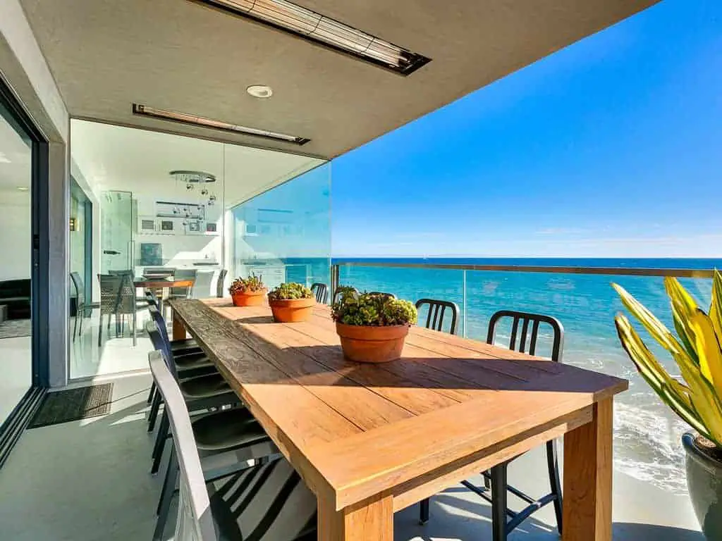 Photo of an outdoor dining table on the balcony of a beach vacation home.