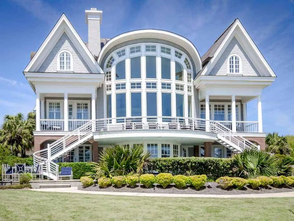 Photo of large beach vacation home with extensive window wall and deck.