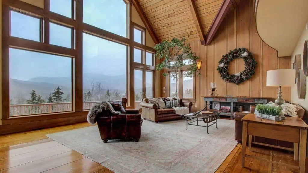 Interior photo of a ski vacation rental home with vaulted ceiling and window wall.