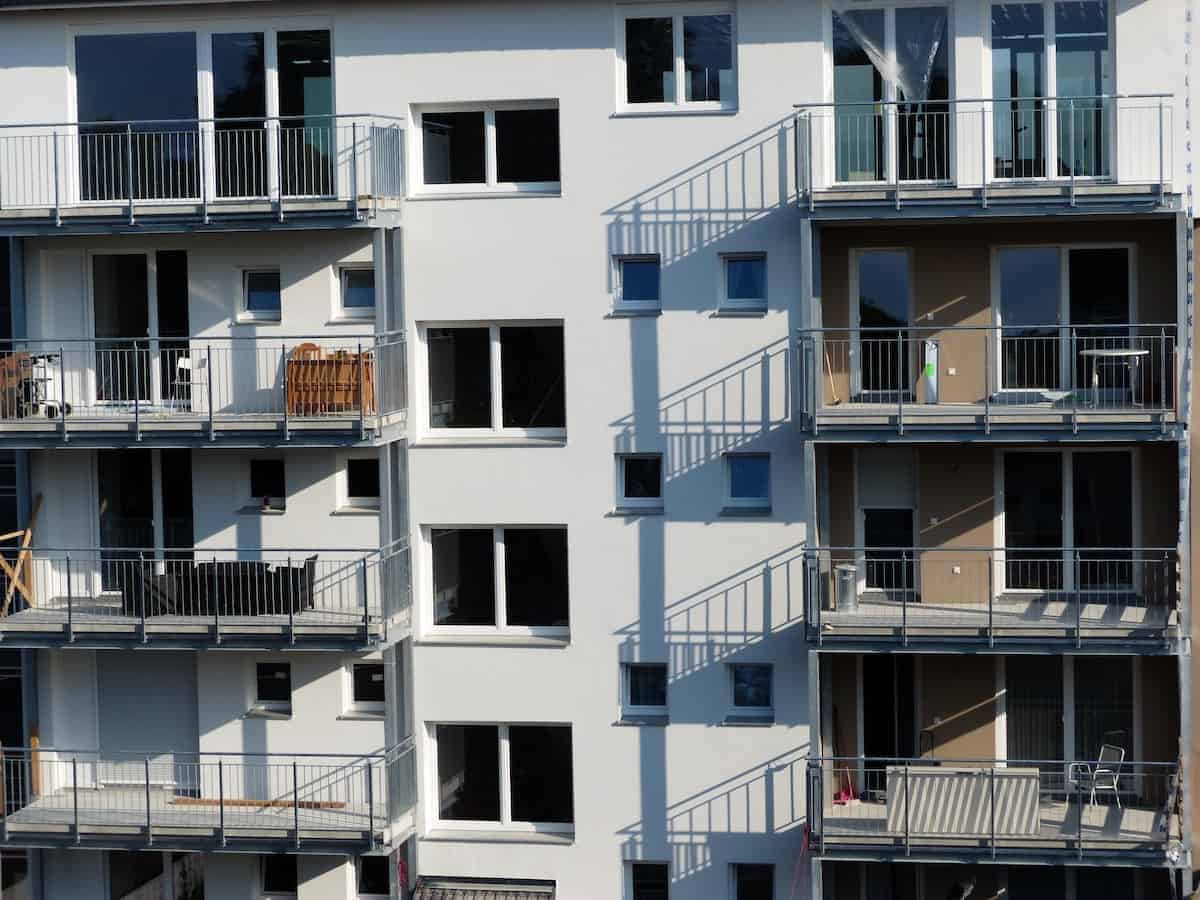 Photo of white building with plain balconies that could benefit from an upgrade of the balcony flooring.