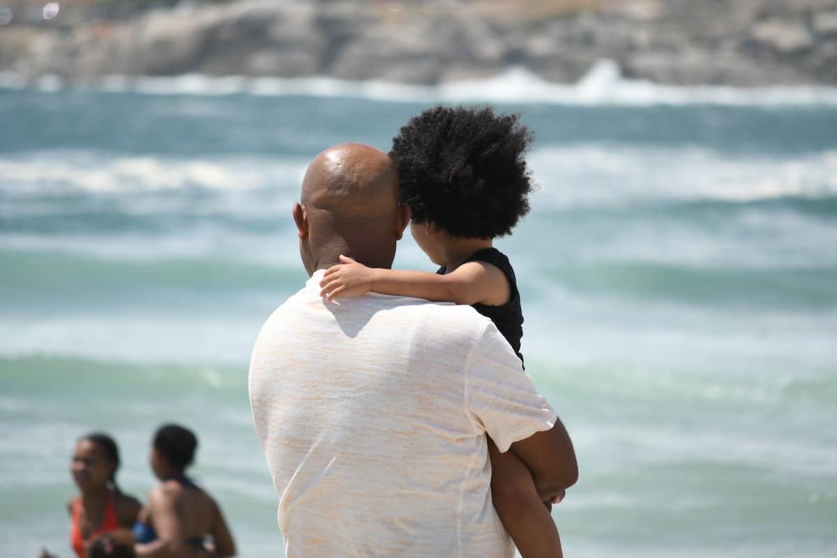 Photo of a dad and daughter enjoying a family beach vacation.