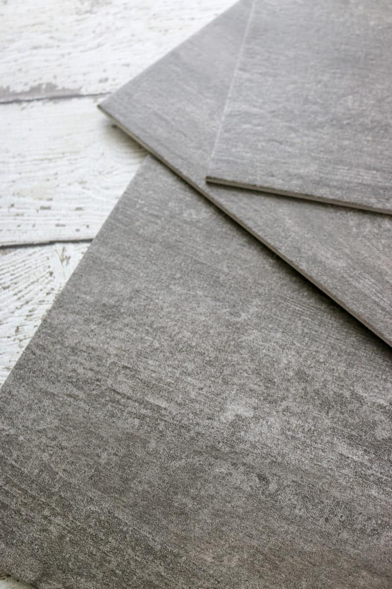 Photo closeup of dark grey luxury vinyl tile flooring pieces
