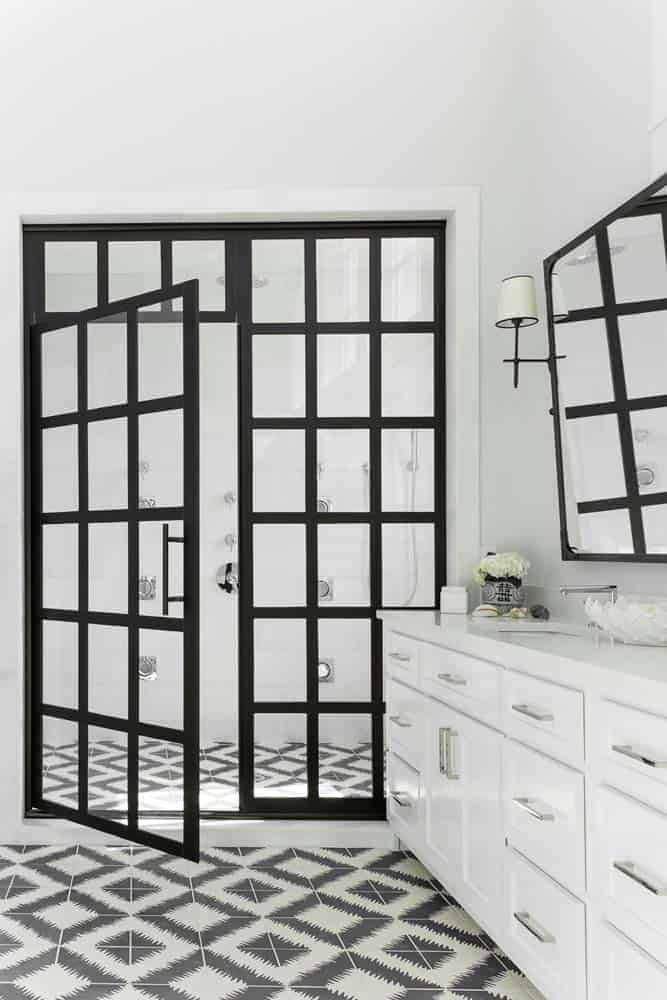 Photo of black framed glass shower enclosure door in a white bathroom. 