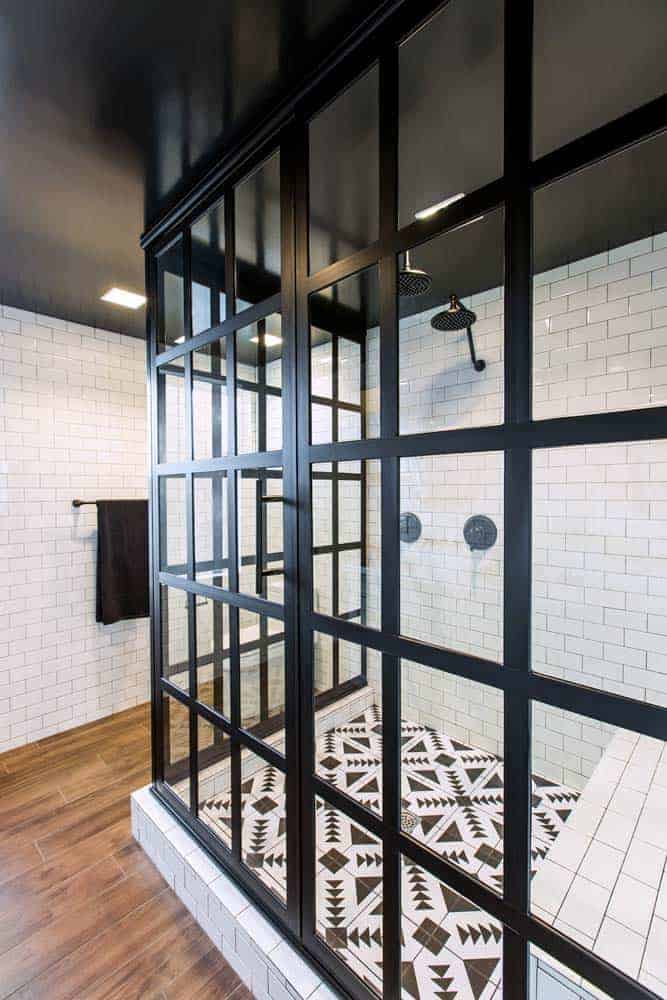 Photo of black framed glass shower enclosure with white subway tiles and black and white tile floor