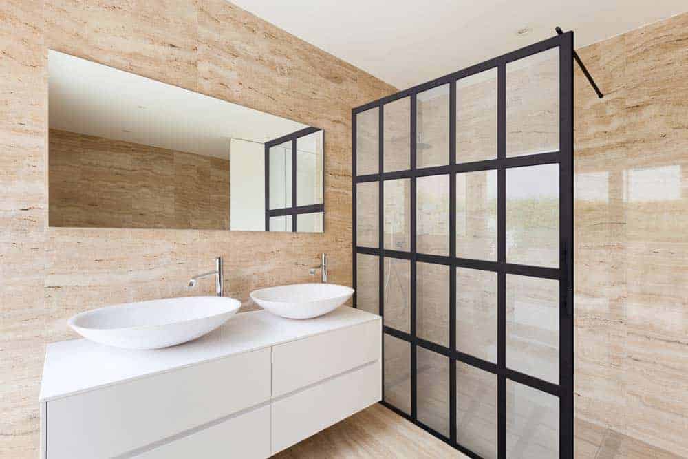 Photo of modern beige bathroom with a black framed glass shower enclosure screen