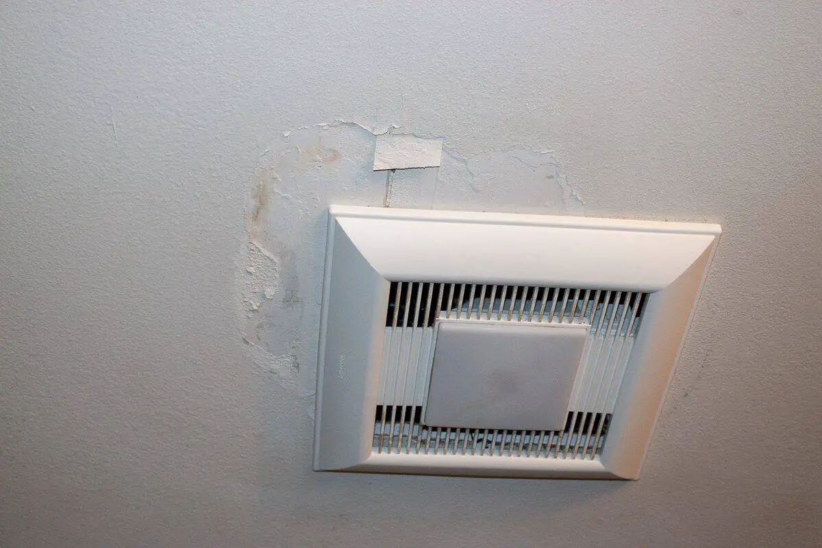 Photo of a bathroom exhaust fan with ceiling damage