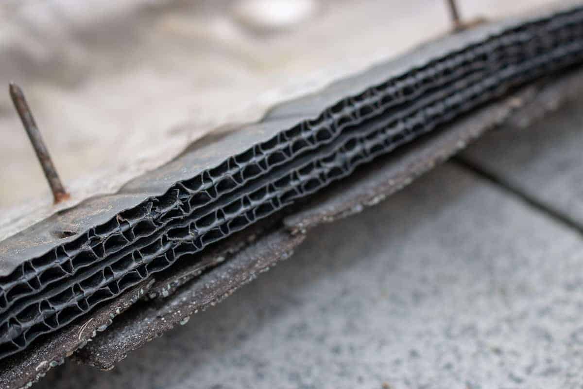 Photo closeup of old roof ridge vent edge of corrugated plastic.