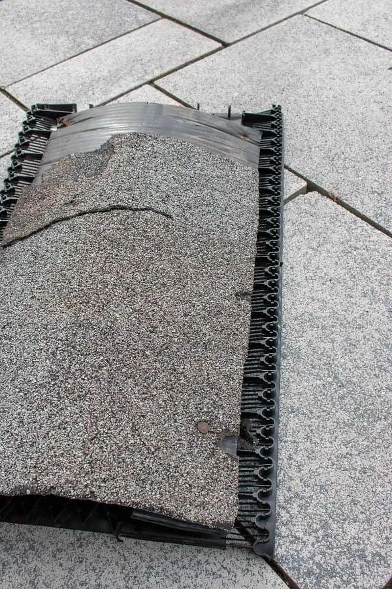 Photo of asphalt shingle with roof ridge vent underneath. 