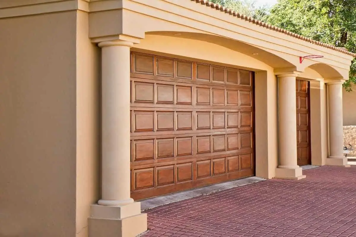 Photo of wood stained garage doors with stucco columns that would make a nice garage conversion. 