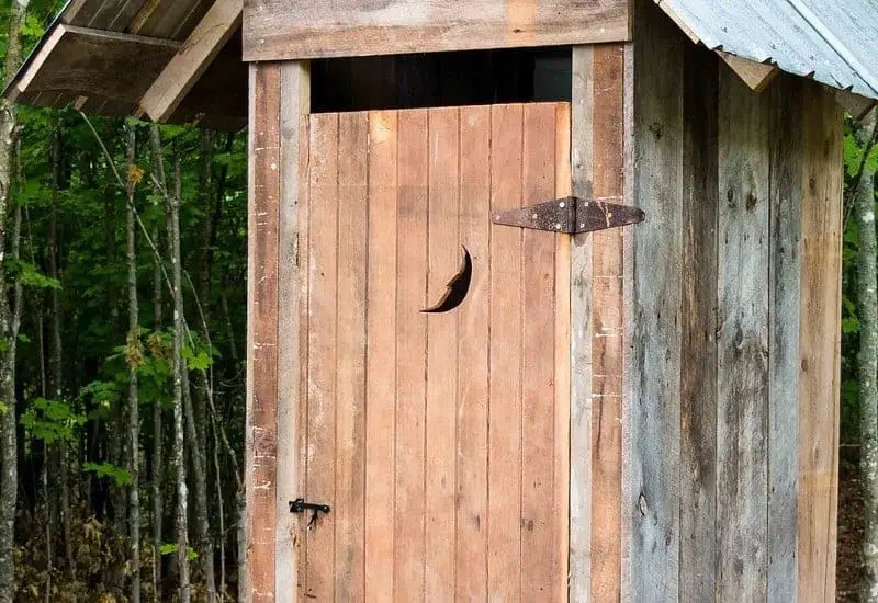 Photo of a rustic outhouse that is a form of septic systems.