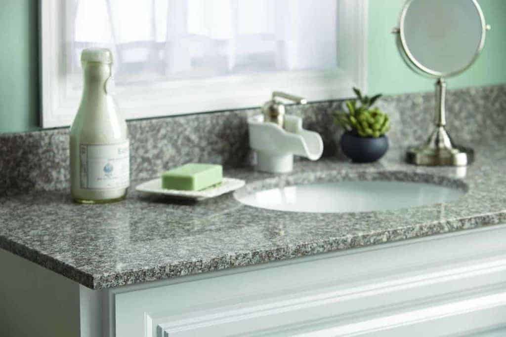 Photo of grey bathroom vanity with old fashioned porcelain faucet.