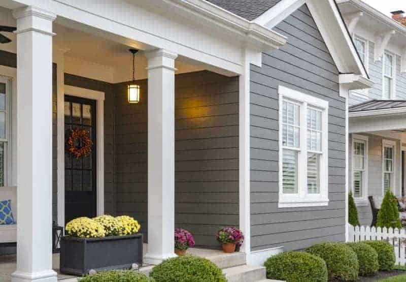 5 Ways to Add Curb Appeal to Your Home 2 Photo of house with dark grey siding and white columns on porch
