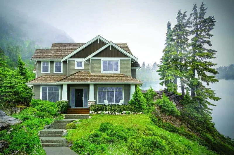 Photo of traditional style home on a mountain lake. 