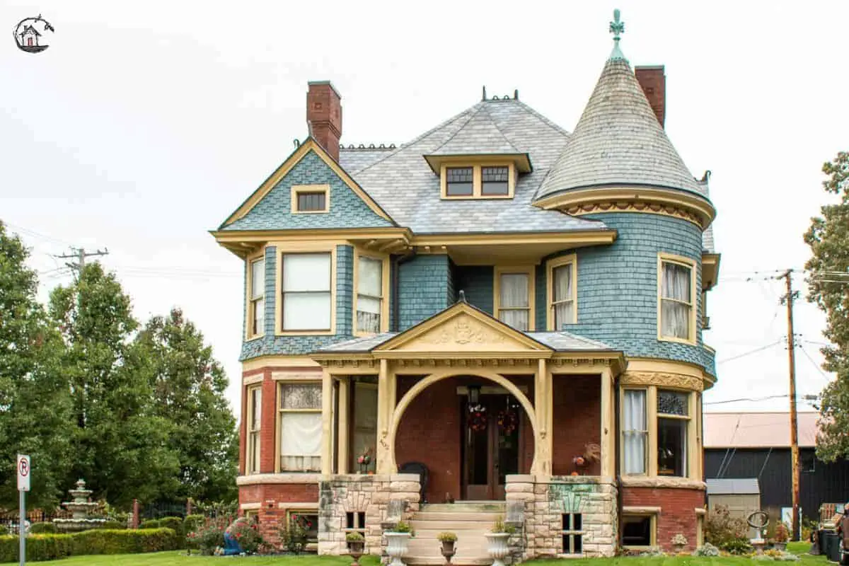 Photo of Victorian home with large front porch, turret, and witch's hat roof. 