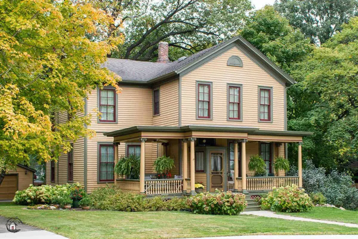 Photo of peach colored farmhouse with large front porch. 