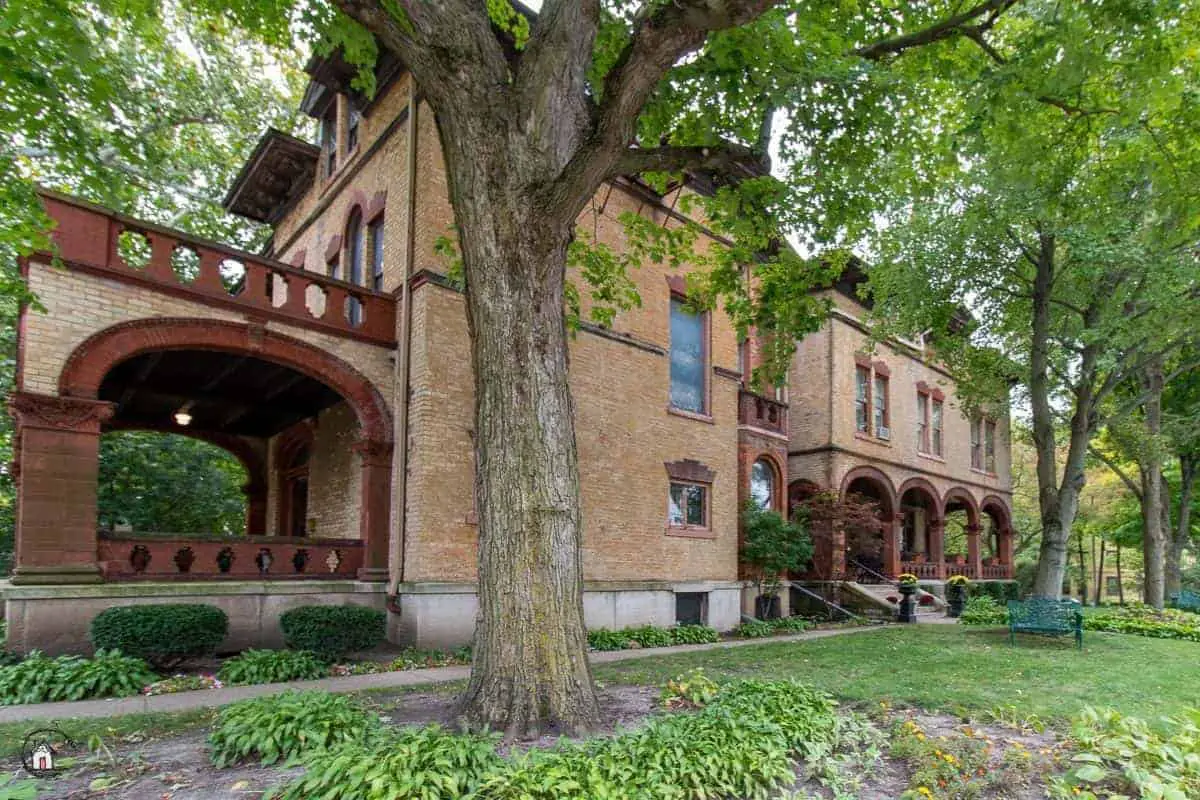 Photo of large brick mansion in a neighborhood of old houses. 