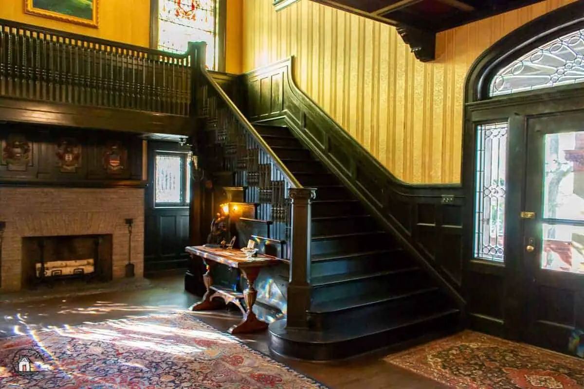 Photo of black stained stairway and foyer of the Vrooman Mansion. 