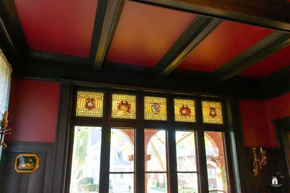 Photo or red ceiling with dark wood coffering, and stained glass windows in the Vrooman Mansion. 